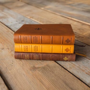 Stack of three ESV Schuyler Bibles on a wooden table